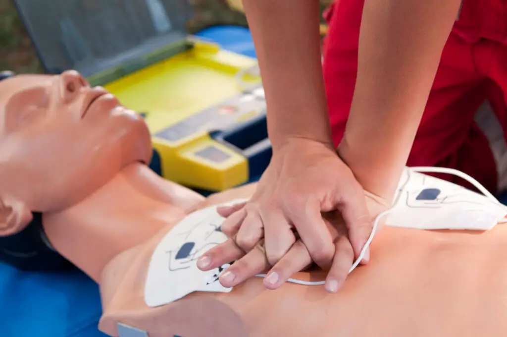 Person performing CPR on a manikin during CPR training